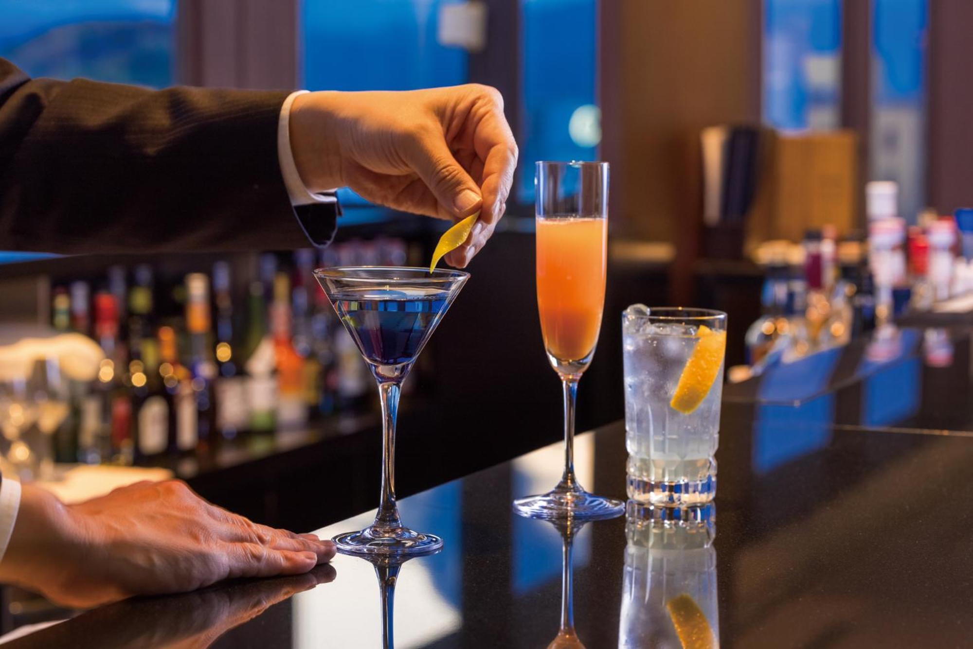 静冈酒店 外观 照片 A bartender adding a lemon twist to a martini